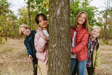 Multiracial four teenagers smiling during hiking in forest
