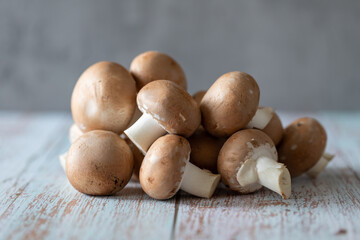 Mushrooms scattered on a light old wooden table.