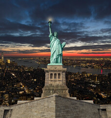 Statue of liberty in New York in USA in background of night overlook from scyscraper. © Ampo
