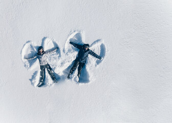 Snow Angels. Aerial view of young couple makes snow angels.
