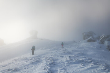 Fototapeta na wymiar two women climbed to the top of the mountain during a fog
