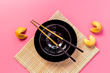 Asian style tabble place setting with fortune cookies and golden chopsticks