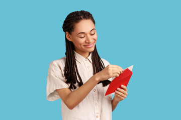 Portrait of smiling woman with black dreadlocks standing open red envelope with congratulations,...