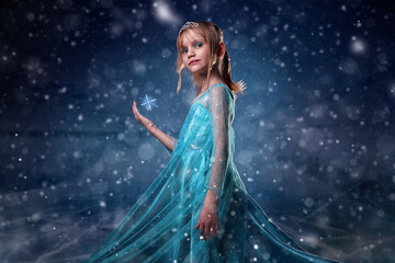 Young girl snow princess. Mystery fantasy girl in blue lush dress. Art background winter frozen and...