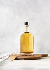 Aromatic homemade elderflower liquor in a bottle on wooden cutting board. (Sambucus nigra) Space for text.