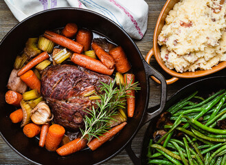 Pot roast in a cast iron dutch oven, green beans and mushed potato. - Powered by Adobe