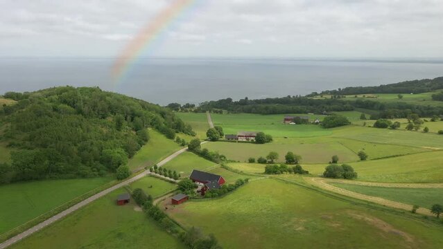Aerial view of farm on "Bjarehalvon", Sweden with rain and rainbow
