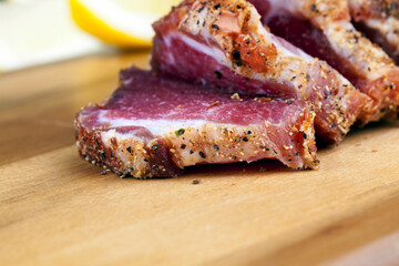 dried and spiced meat sliced on a wooden board