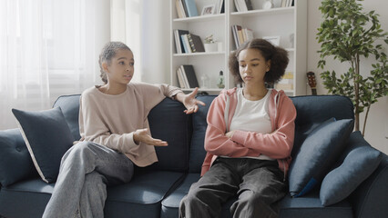 Sad black girl talking to female friend at home, discussing problem, support