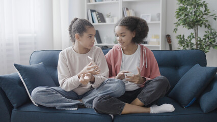 Cheerful girls looking through photos on smartphones, online dating app, social network