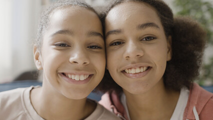Joyful African American siblings smiling on camera together, close relationship