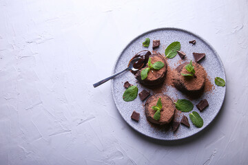 Composition with chocolate fondants on a gray background with place for text. Decorated with mint