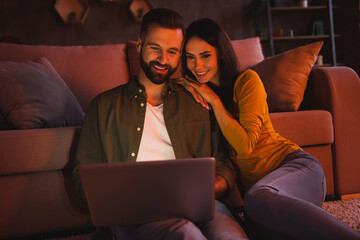 Photo of bonding lady guy spouses sit floor watch netbook interesting movie in modern late dark room