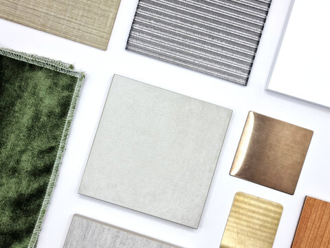 samples of interior material in top view containing grey stone tiles, green velvet drapery, wooden veneer, corrugated glass, white quartz, aluminum plate for selection. interior material board.