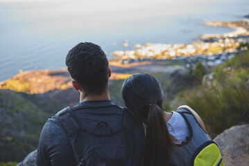 .. Shot of a young couple enjoying the sunset view while out on a hike on a mountain range.