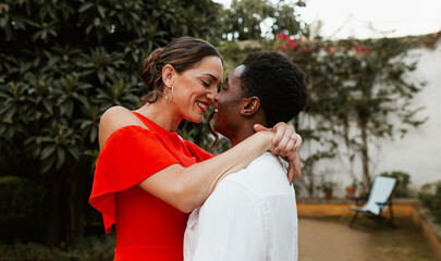 Young interracial couple going in for a kiss in a backyard