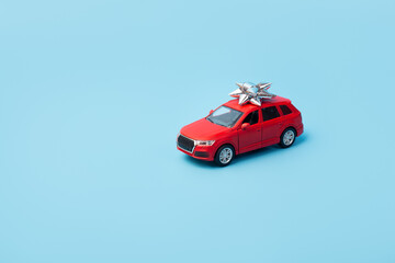 Present, gift red car on isolated blue background with copyspace. Mockup. Flatlay. Business concept