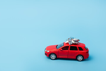Present, gift red car on isolated blue background with copyspace. Mockup. Flatlay. Business concept