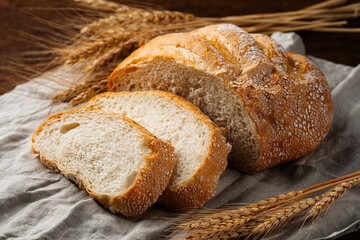 Freshly baked sliced loaf of creamy bread on napkin 