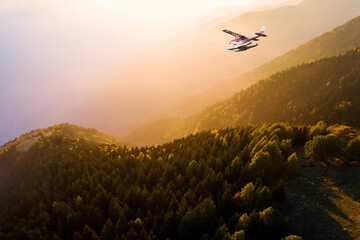 seaplane in flight at sunset over the alps