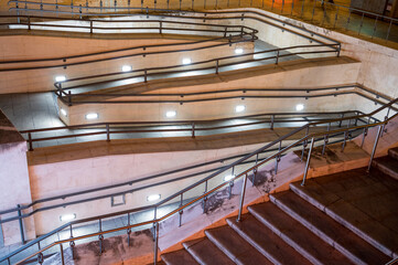 Large access ramp to a building for disabled people. Safety railing and night lighting