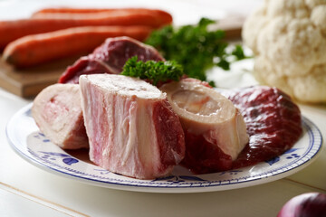 Ingredients for preparation of beef bone broth or soup - marrow bones, parsley, carrots, cauliflower