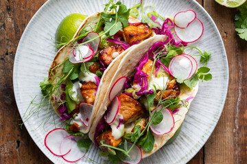 Tacos with salmon, pickled red cabbage, wasabi mayo and pea shoots
