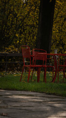 Fototapeta na wymiar a garden, table and red chairs