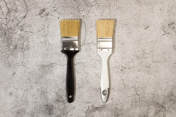 Pinceles de pintura sobre un fondo gris agrietado de cemento. Vista superior. Copy space