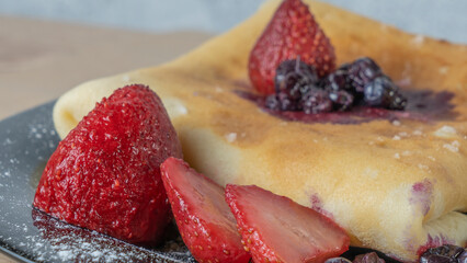 Classic american pancake with berry on black plate background. Crepe with blueberry and strawberry.