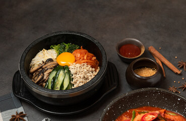 Bibimbap korean food. Korean Bibimbap Mixed Rice with egg,  vegetable, kimchi, mushroom and pork chop in black bowl. Korean food concept.