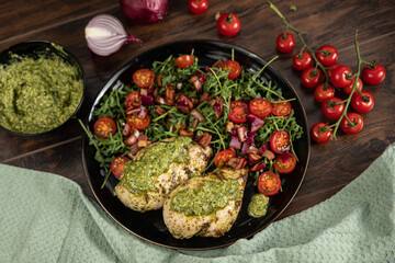Fototapeta na wymiar Chicken breast baked in nut and parsley pesto with red onion salad
