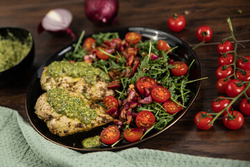 Chicken breast baked in nut and parsley pesto with red onion salad