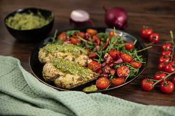 Chicken breast baked in nut and parsley pesto with red onion salad