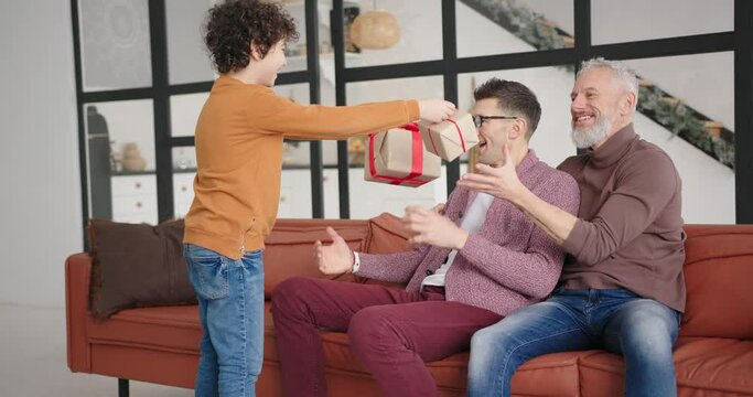 Boy gives presents to gay parents for anniverasy celebration