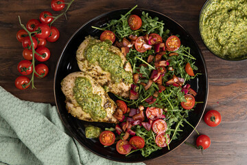 Chicken breast baked in nut and parsley pesto with red onion salad