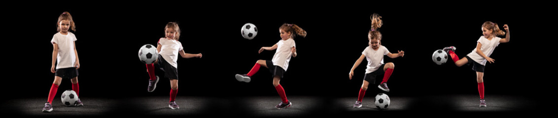 Full-length portrait of little girl, child, training, playing football isolated over black studio background. Collage