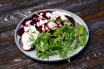 Selective focus. Macro. Vegan food. Beetroot arugula salad on a plate with yogurt sauce and olive oil. Healthy food. Diet salad.