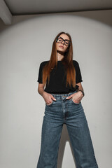 Pretty cool stylish girl with vintage eyewear glasses in black fashion t-shirt and wide leg jeans...