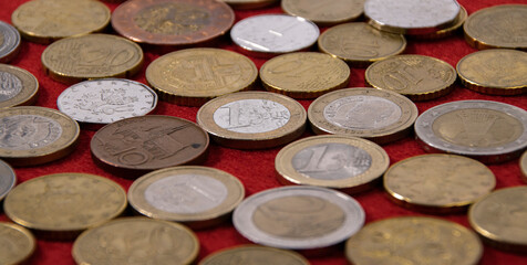 european coins on red cloth, selective focus, close-up
