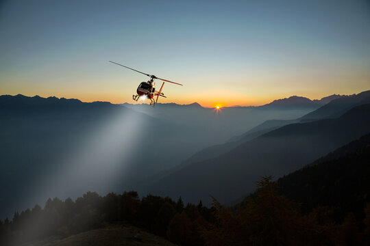 helicopter with lighthouse in night flight in the high mountains