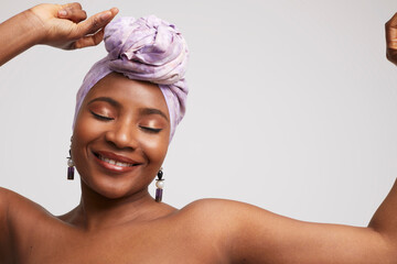 Studio shot of smiling woman in headscarf and ethnic earrings