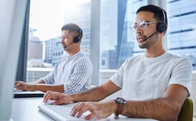 Together well go further. Shot of two business colleagues working together at their desks in their...