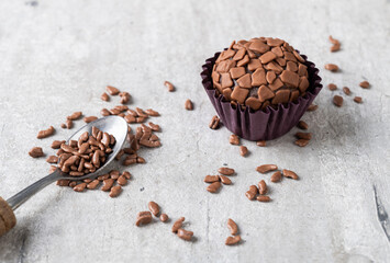 Typical brazilian brigadeiros with chocolate sprinkles over wooden table