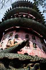 Exterior building with king of serpent naga and chinese dragon wrapped around tower for thai people travel visit and respect praying of Wat Samphran temple at Sam Phran city in Nakhon Pathom, Thailand
