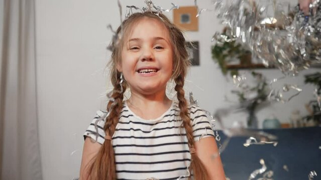 baby birthday. happy little girl throwing a up silver confetti. birthday kid dream concept. happy joyful girl on holiday throws up shiny confetti. child on holiday slow fun motion video