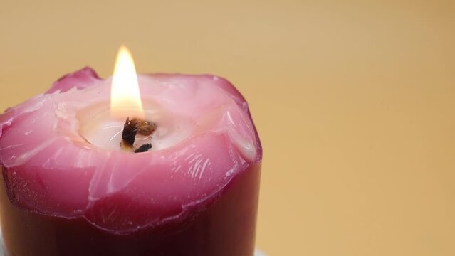 burning candle on a yellow background