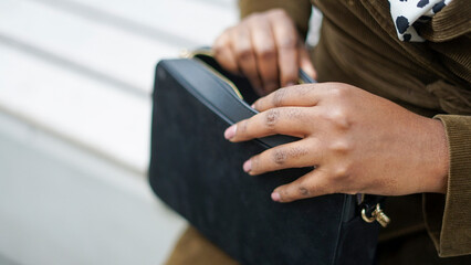 Woman reaching into purse, close up