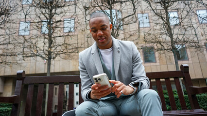 Business man using phone outside office building