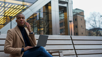 Business man using phone and laptop in city © Cultura Creative